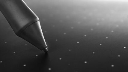Black pen on graphic tablet surface, closeup. The work of an artist or illustrator.